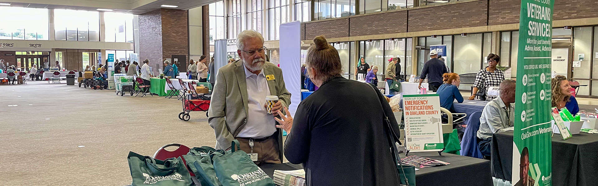 Jim Ellison at the Senior Expo 2023 talking to an attendee.