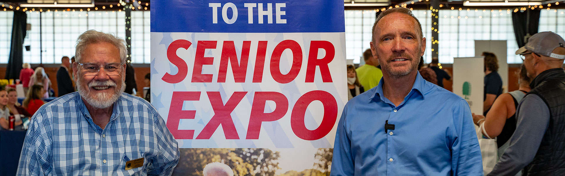 County Executive David Coulter and Jim Ellison posed in front of the sign at the Oakland County Senior Expo in Royal Oak.