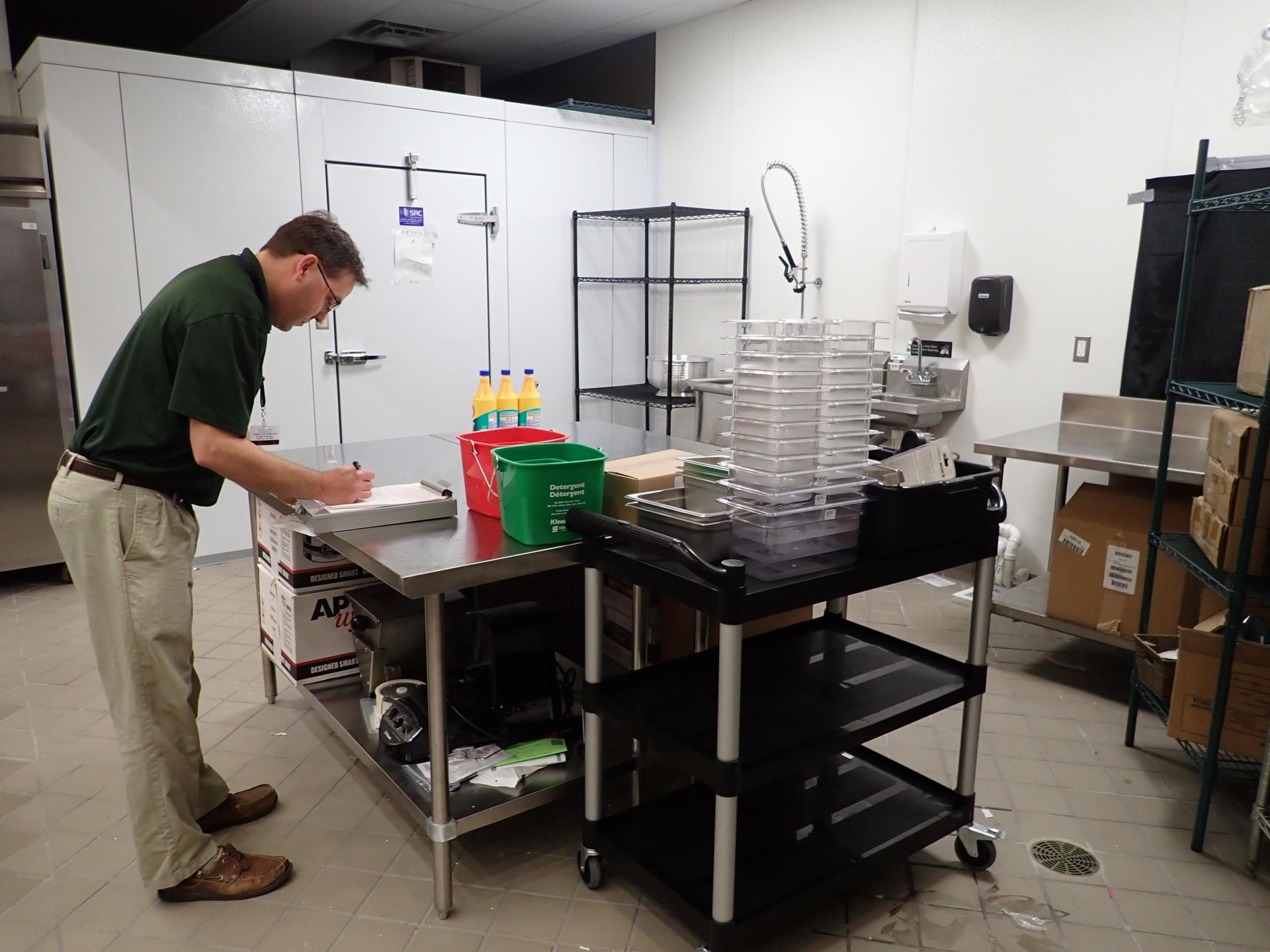 Public Health Sanitarian in a kitchen conducting a plan review.