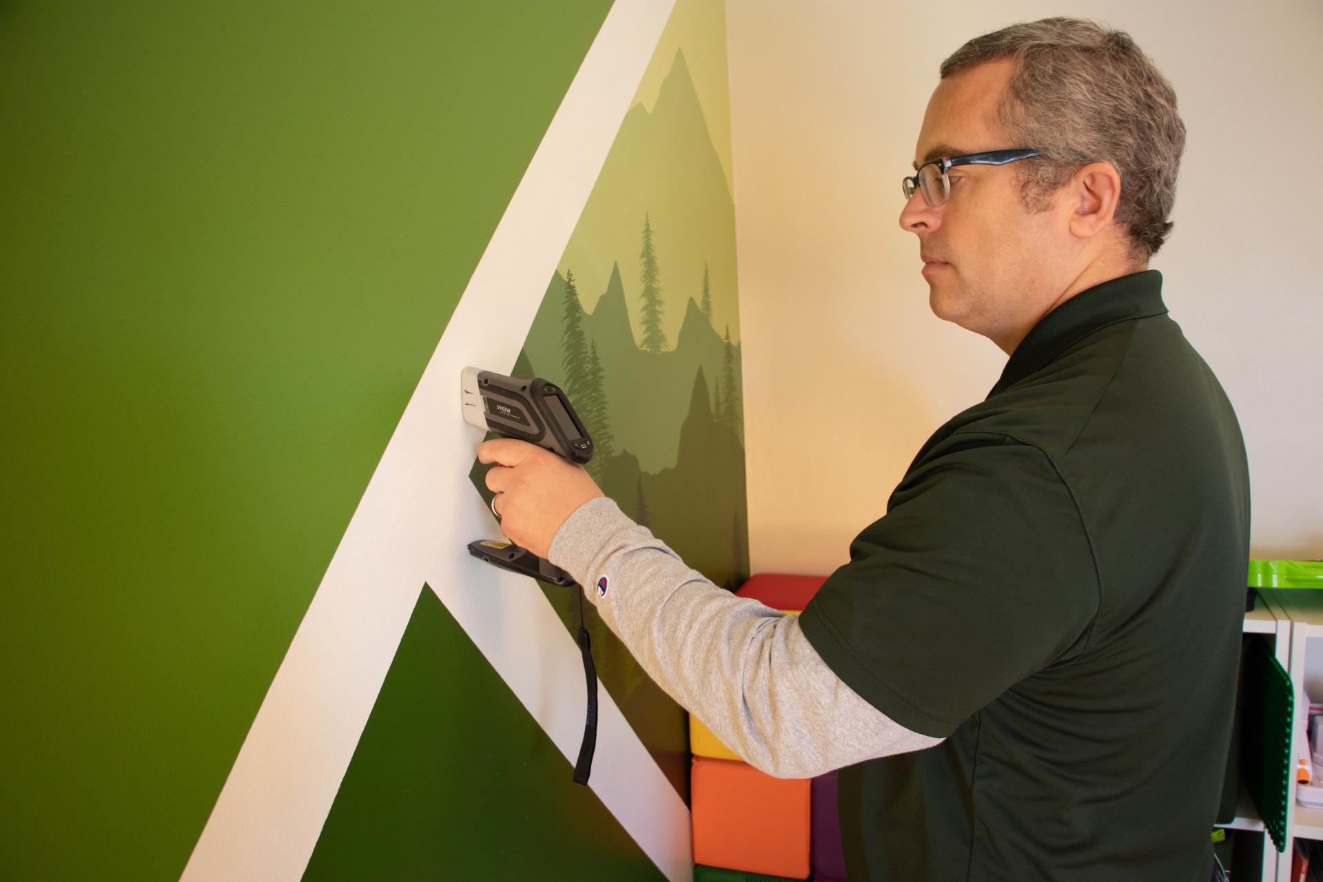 Public Health Sanitarian testing a wall for lead paint.