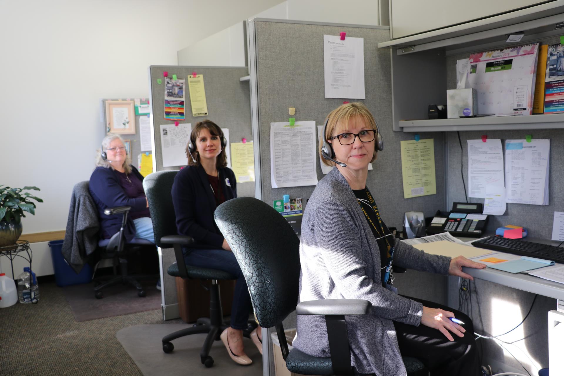 Nurses answering phone calls in an office.