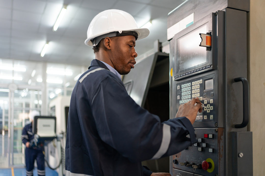 CNC Machine engineer working at the control panel.