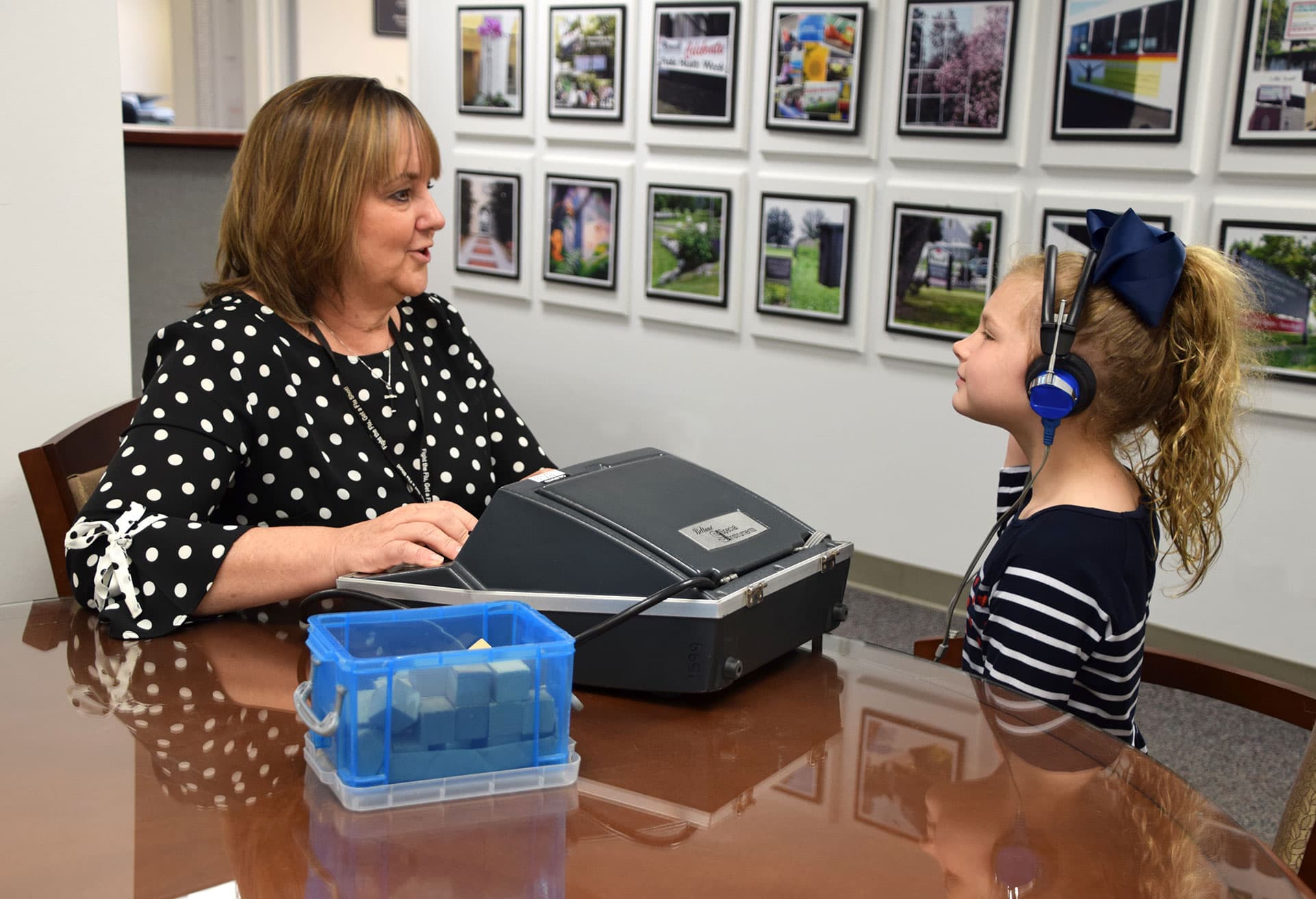 A child receiving a hearing screening from a technician.