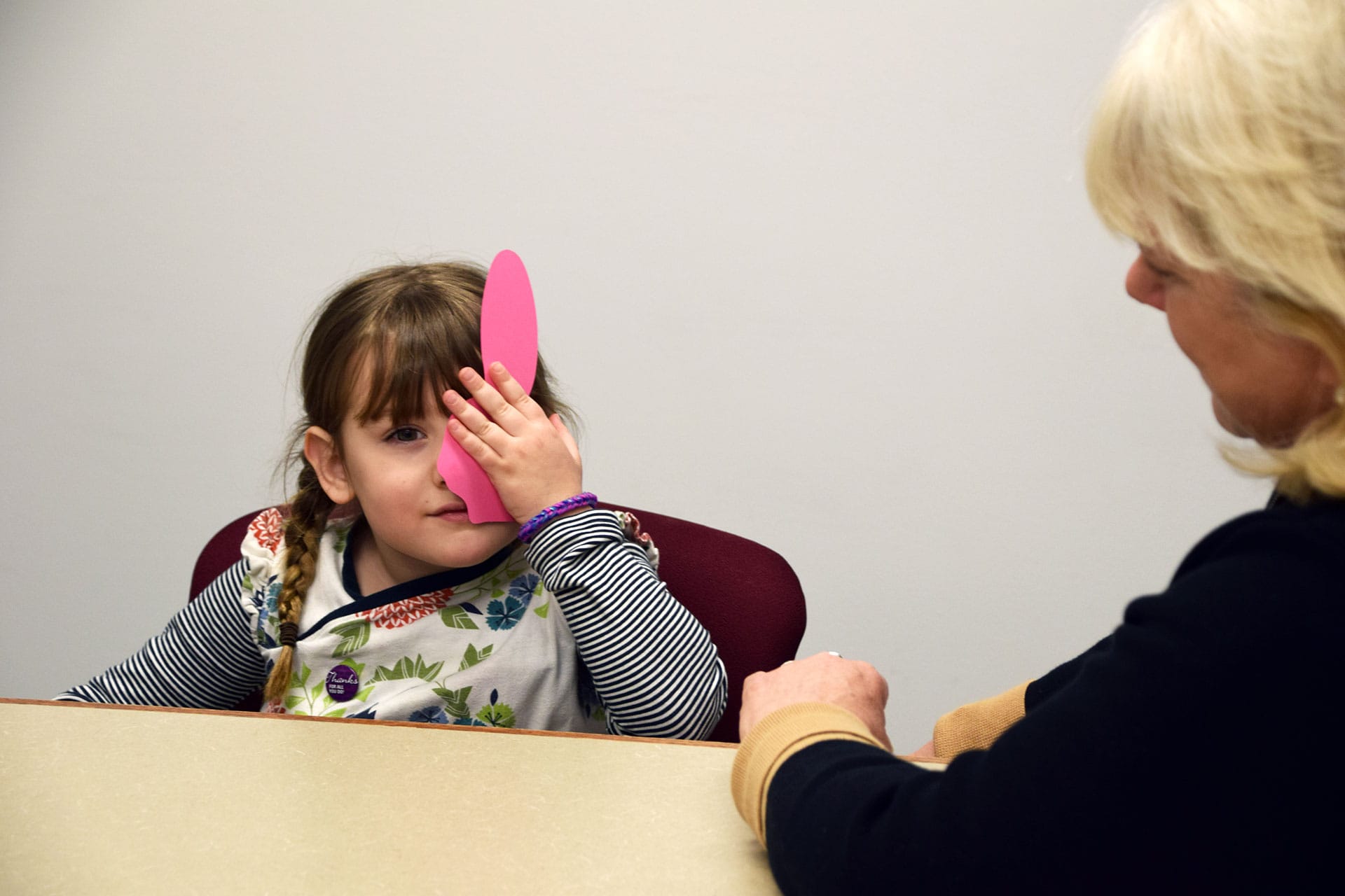 A child receiving a vision screening from a technician.