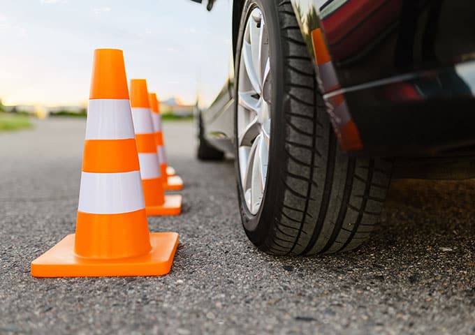 Several orange traffic cones placed along the roadside, indicating a construction zone or a need for caution.