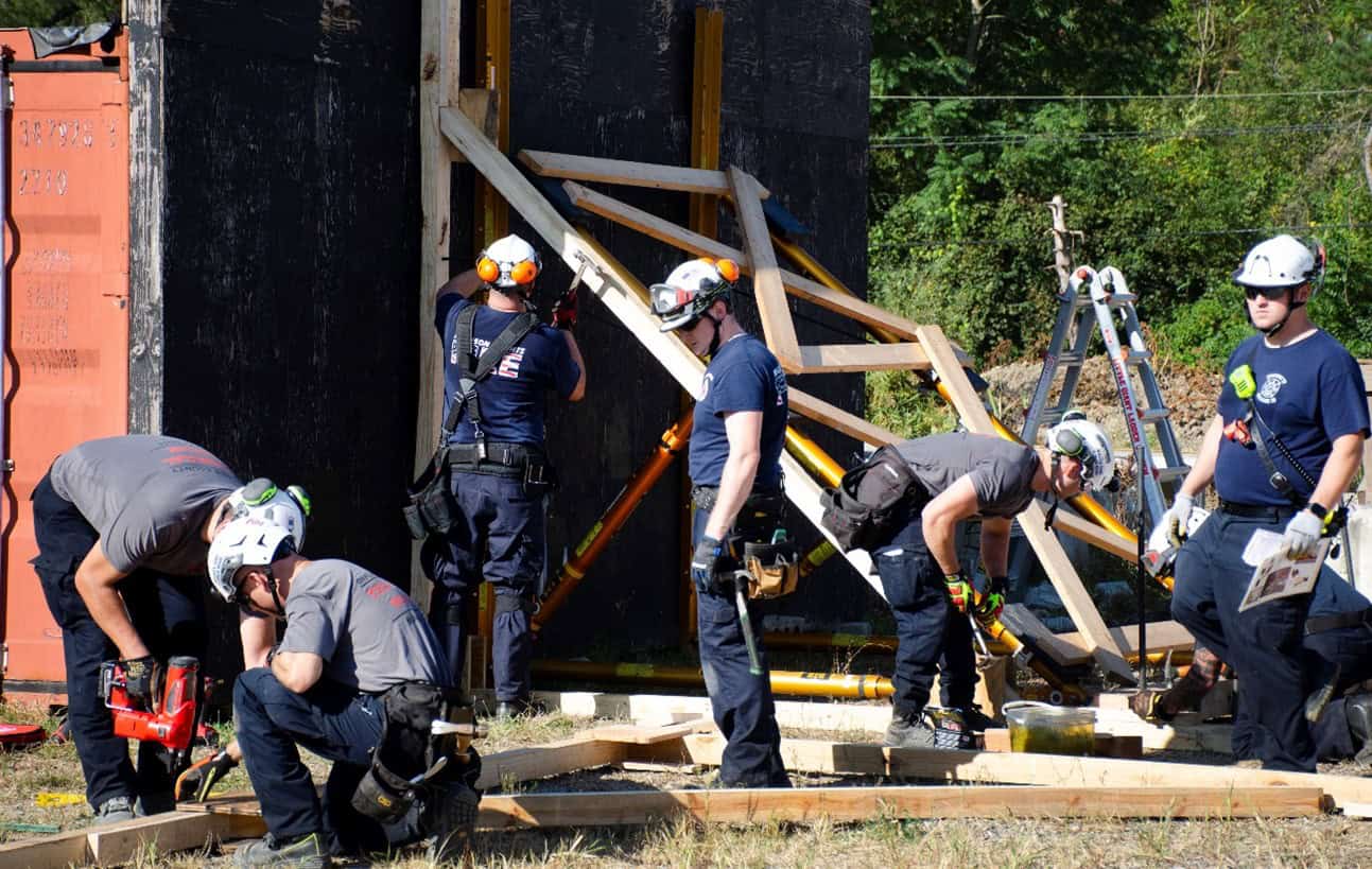 Several men collaborating on a construction site, wearing helmets and focused on their tasks.