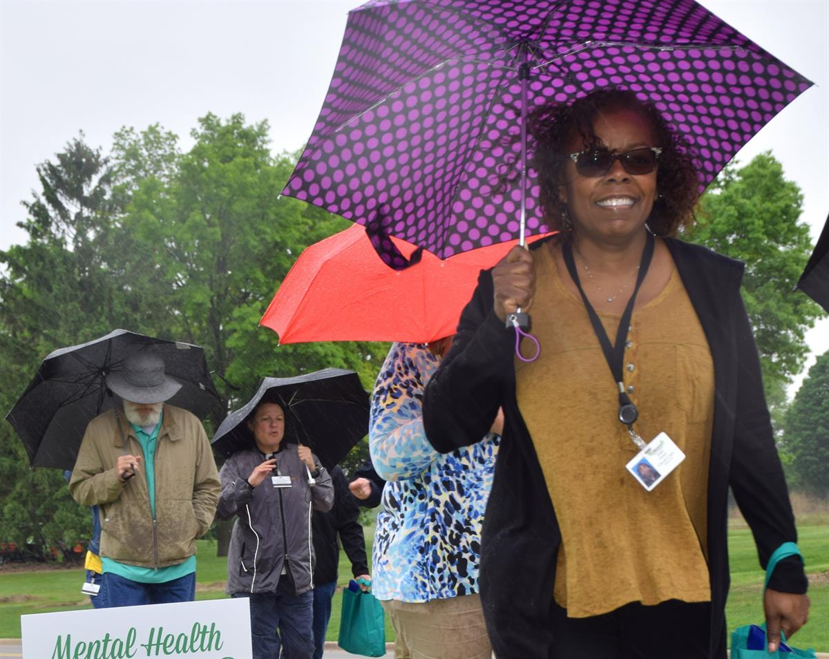 Oakland County Employee walking with a smile.