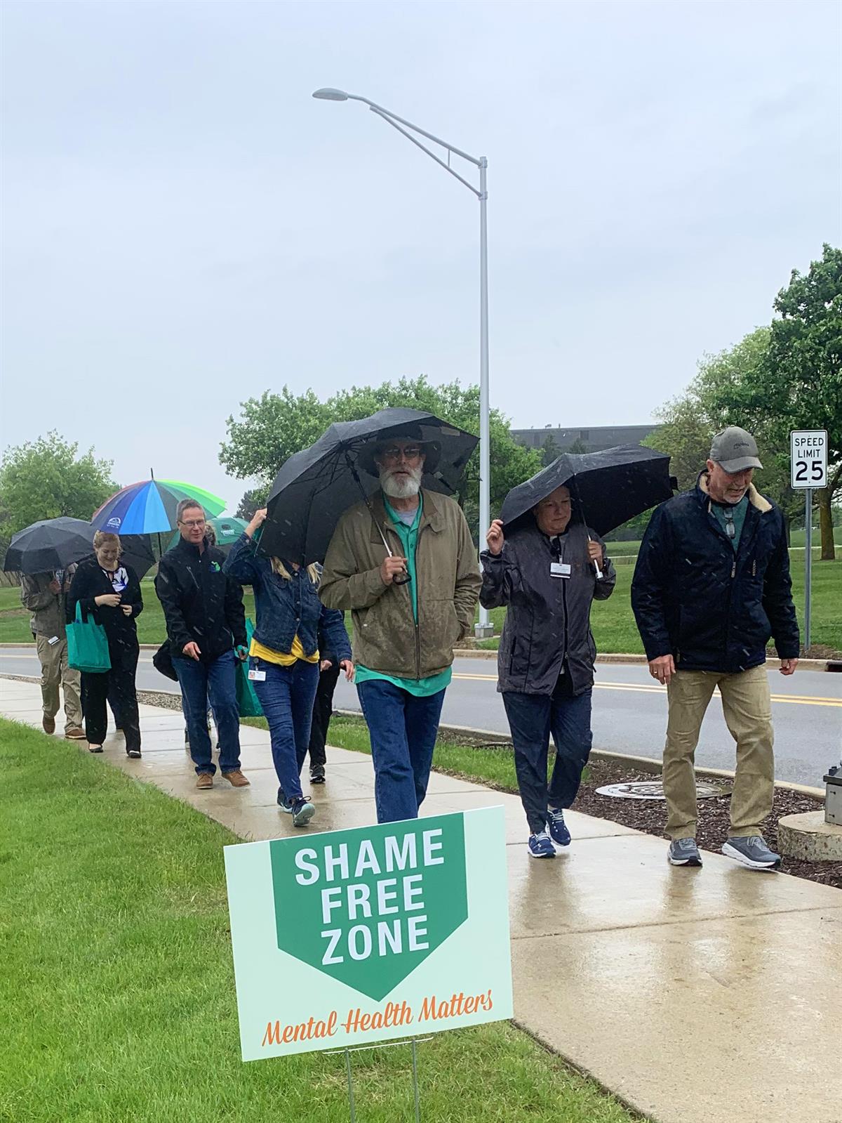 Oakland County Employees walking on the sidewalk in the rain.