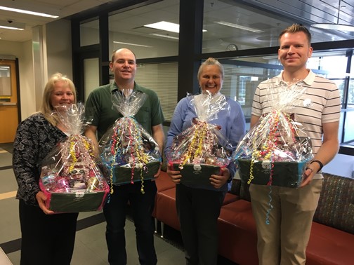 Group picture holding gift baskets