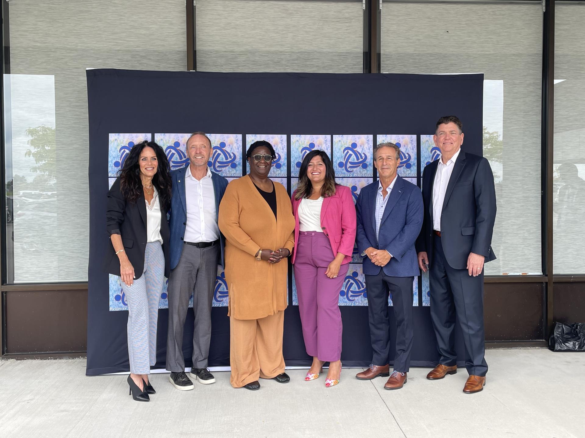 A photo shows Oakland County Executive Dave Coulter posing with five people following a press conference on opioid settlement listening sessions.